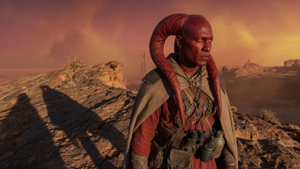Red-skinned Lethan Twi'lek man with patterned lekku against a Ryloth sunset